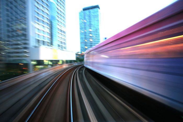 a photo of a train rider's view of a railway as the train lurches forward on its tracks amid the emergence of urban rail systems