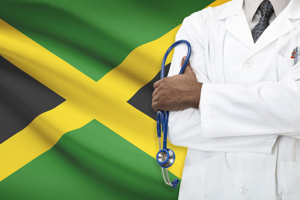 Doctor in front of a Jamaican Flag.