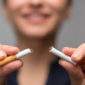 a photo of a woman breaking a cigarette in two because of the bold impact of the SmartQuit app