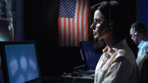 Woman in front of flag and computer
