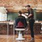 a photo of a barber shaving the head of a man's head inside a stylish barber shop while scientists discover a stem cell hair growth cure