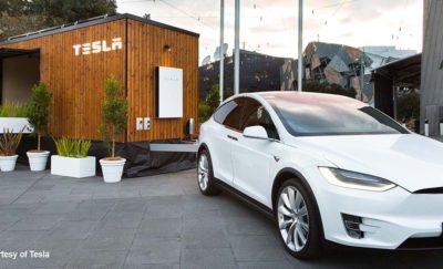a photo of a white Tesla X that is powered by the Tesla Powerwall Tiny House it hauls