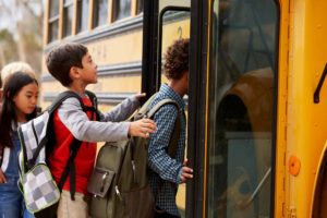 Kids getting on a school bus.