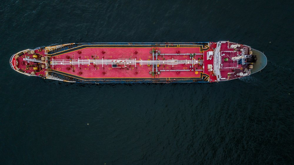 a photo showing an aerial view of an oil tanker amid the existence of bitumen pellets