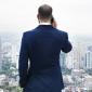 best cities to start a business, man on his back facing a cityscape holding a phone to his ear