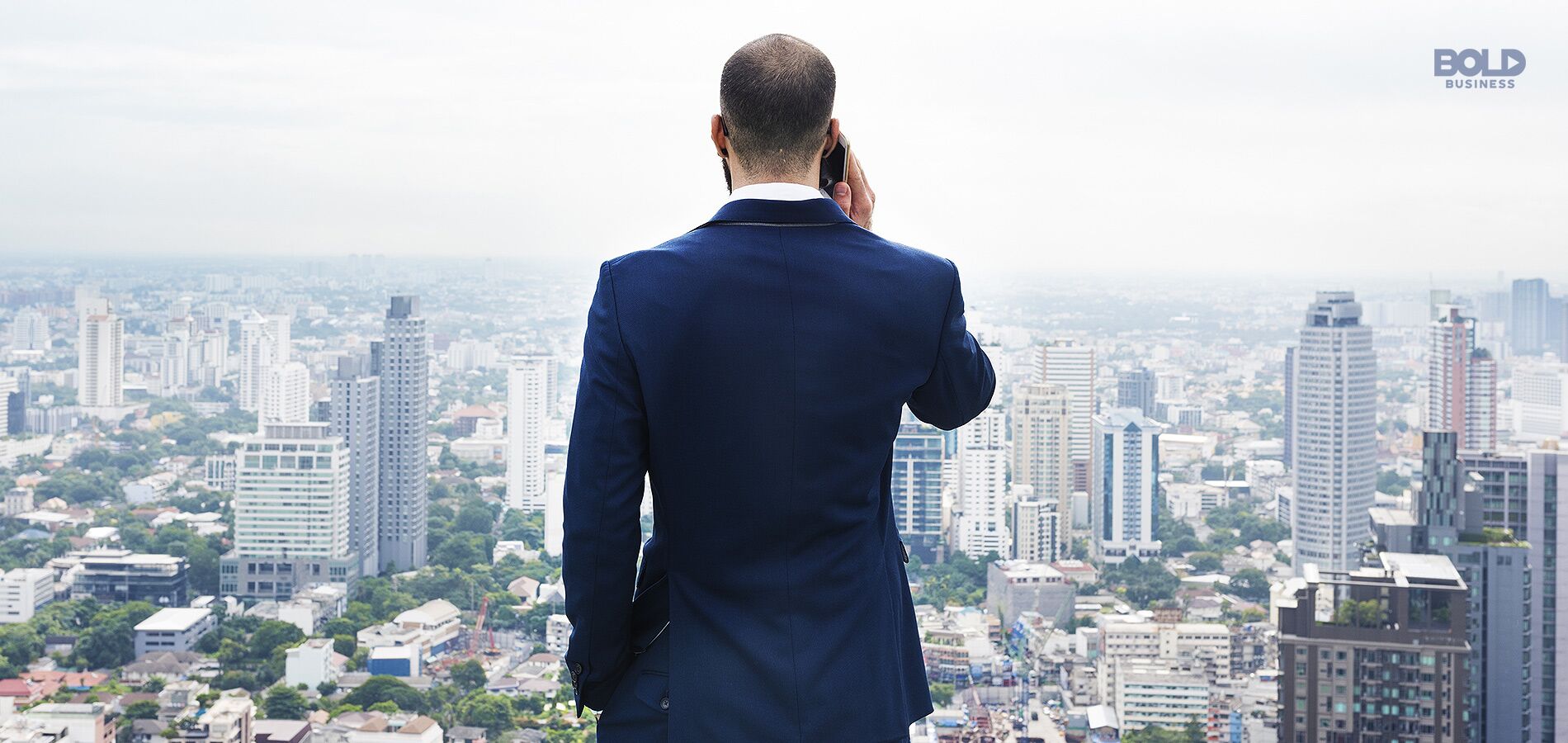 best cities to start a business, man on his back facing a cityscape holding a phone to his ear