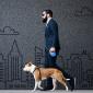 a photo of a man in a business suit walking his dog alongside a wall with a background of an etched city in gray amid the growth of the pet industry