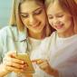 a photo of a young mother with her middle-school aged daughter looking at a smartphone that has several good apps for kids and best apps for kids installed in it