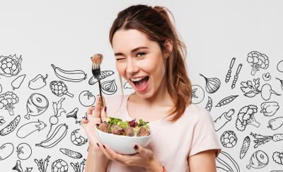 a photo of a woman holding up a fork with a piece of meat and a bolw filled with an assortment of vegetables and meat to depict what a flexitarian diet looks like