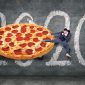 a dude sidekicking a giant pizza