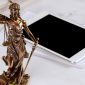 A scales of justice statue and an iPad