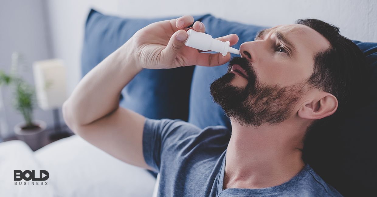 A dude giving himself a blast of nasal spray