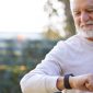 An older dude checking his wearable health monitor