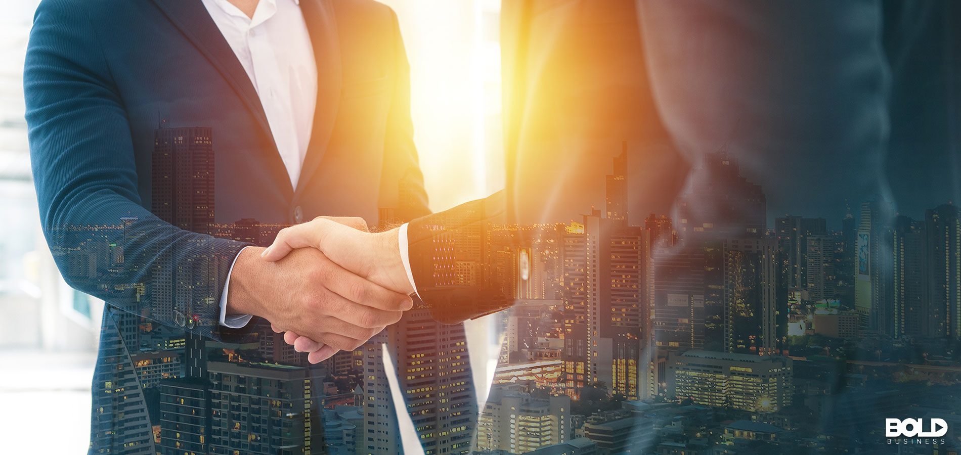 Two businessmen shaking hands before the sun