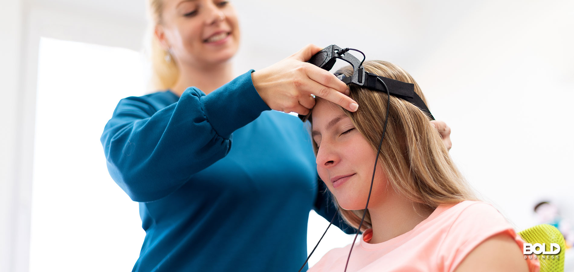 A woman helping another woman with her neurofeedback device