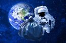 A space man floating around with a garbage bag