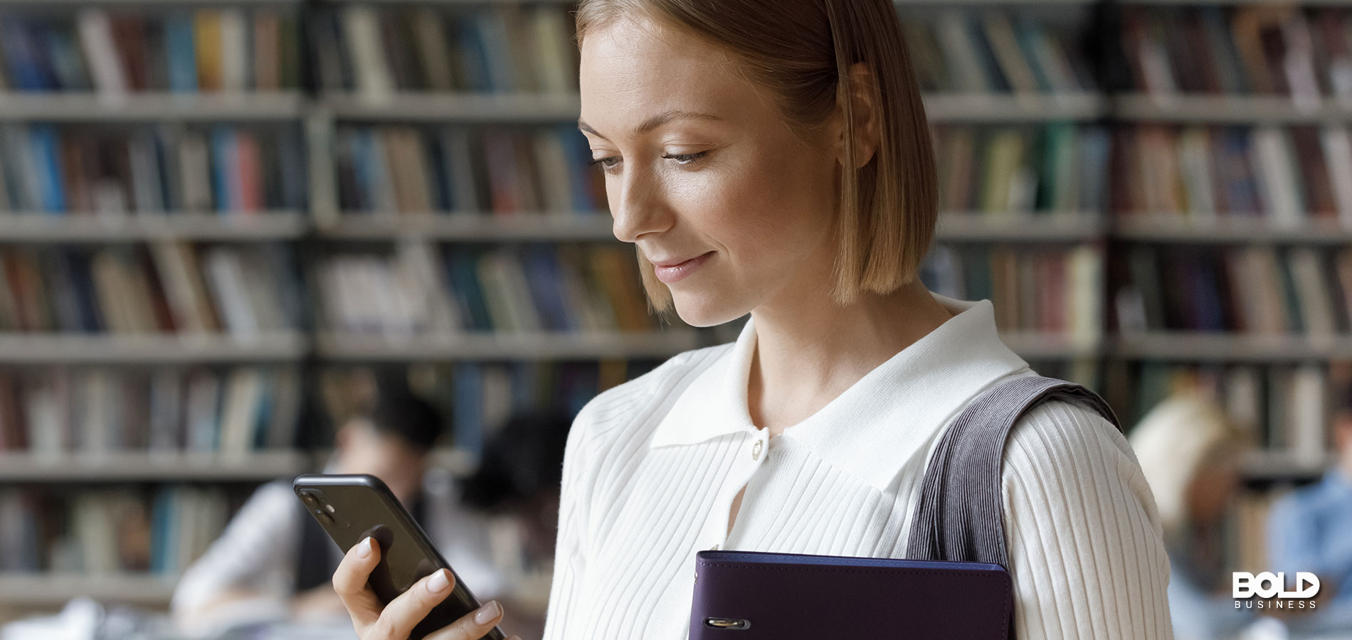 A student reading a textbook on her phone