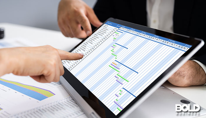 a person pointing at data on their tablet