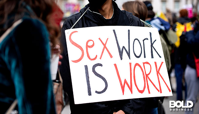 Someone holding up a sex work is work sign