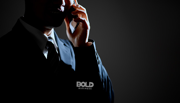a sinister dude making a phone call